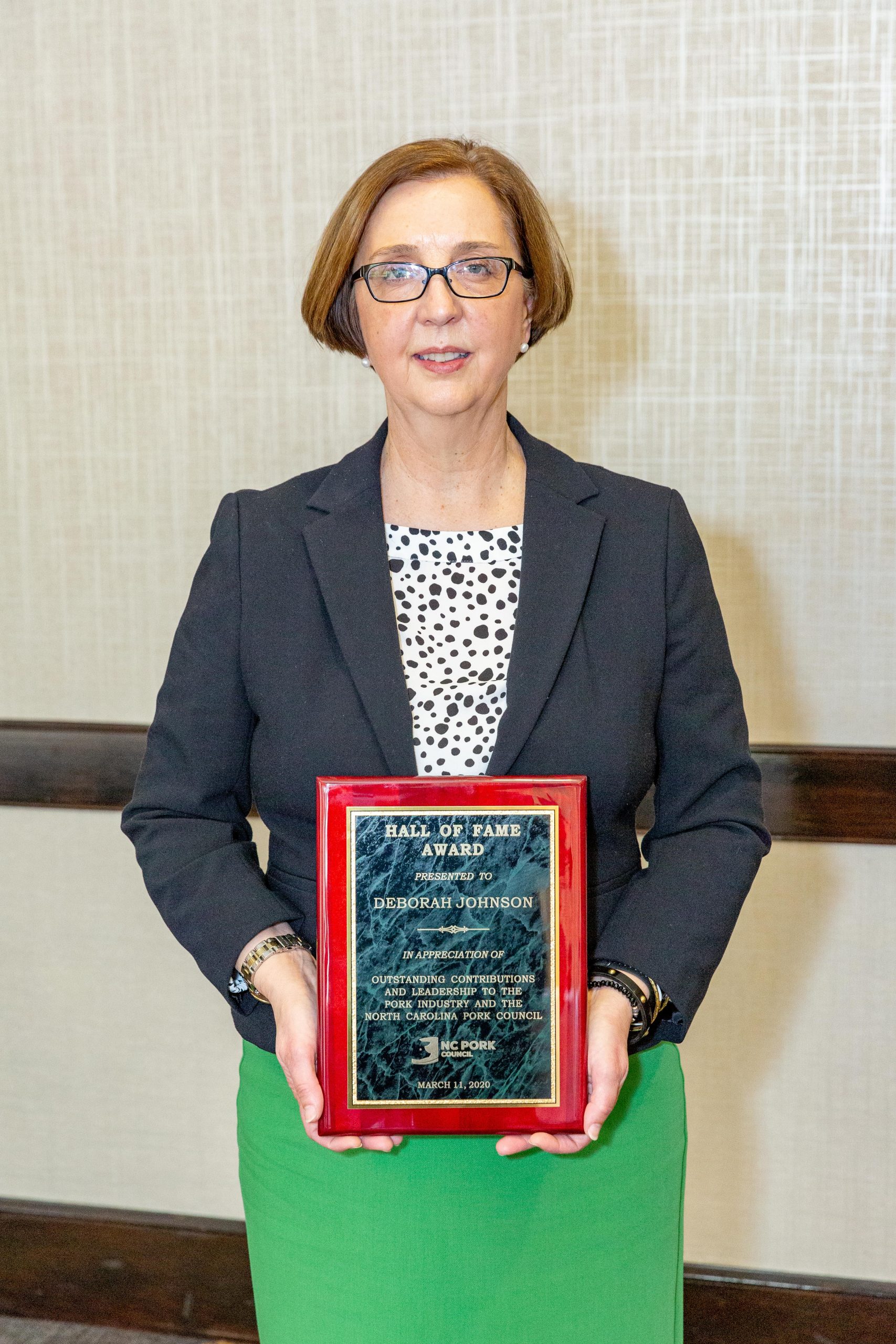 Deborah Johnson holding Hall of Fame plaque